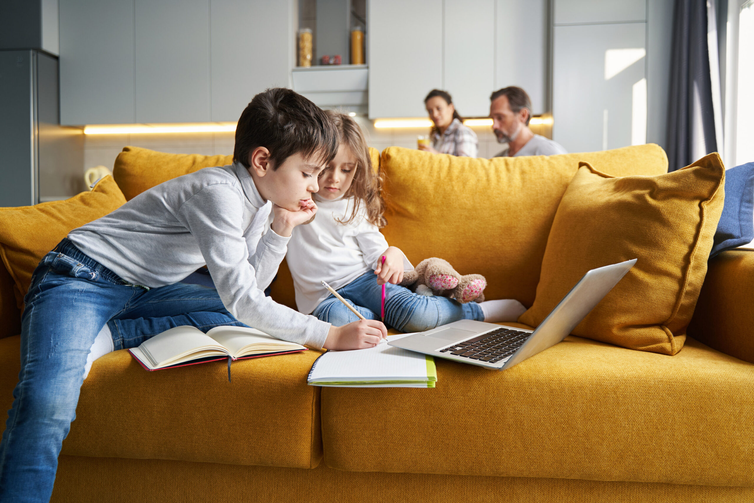 kinderen maken een vakantietaak in de zetel